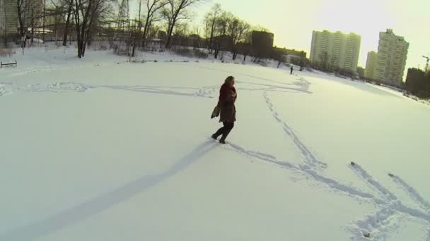 Woman circling on snowbound pond — Stock Video