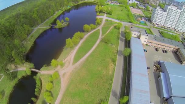 Pequena lagoa perto de floresta e cidade — Vídeo de Stock