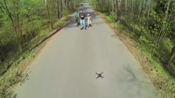 Far med barnen rida på inlines och cykel — Stockvideo