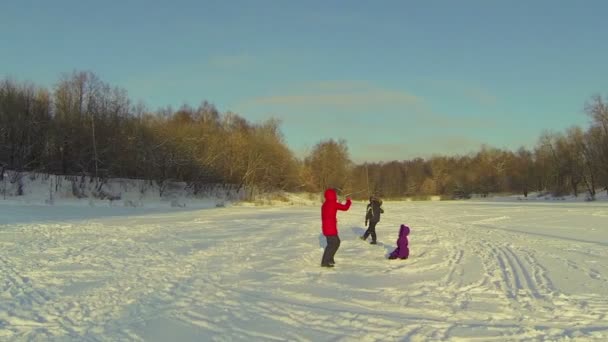Madre con niños jugando en la nieve — Vídeo de stock