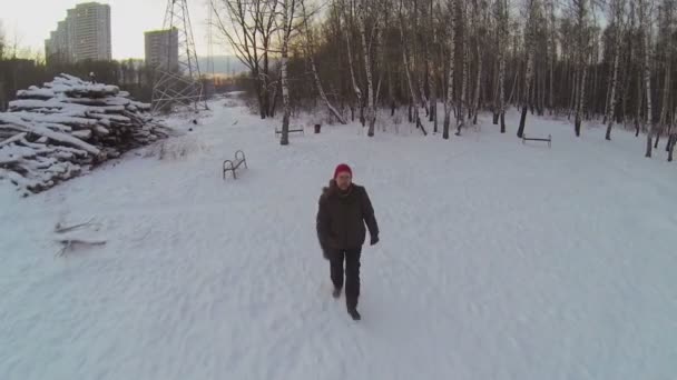 Un homme court dans un parc enneigé — Video