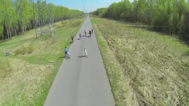 People ride on bicycles by road — Stock Video