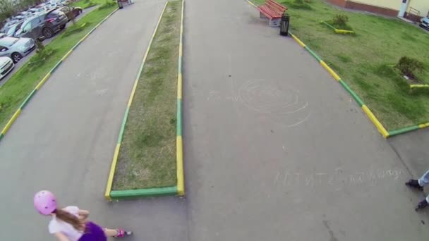 Маленька дівчинка їде на роликових ковзанах — стокове відео
