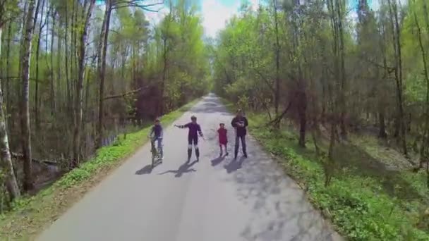 Parents and children ride on rollerblades and bicycle — Stock Video