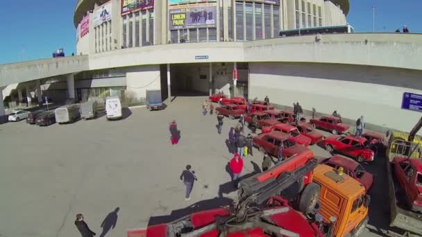 As pessoas caminham perto de muitos carros vermelhos velhos — Vídeo de Stock
