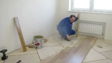 İşçiler bir pencere yakınında parke koydu