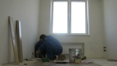 İşçiler bir pencere yakınında parke koydu