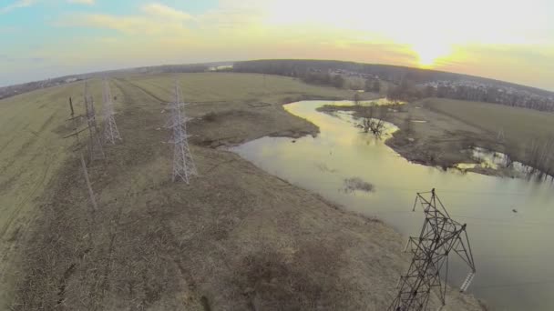 Línea de electricidad en la orilla del río — Vídeos de Stock