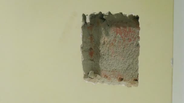 Εργαζόμενος αυλακώσεις τρύπα στον τοίχο — Αρχείο Βίντεο