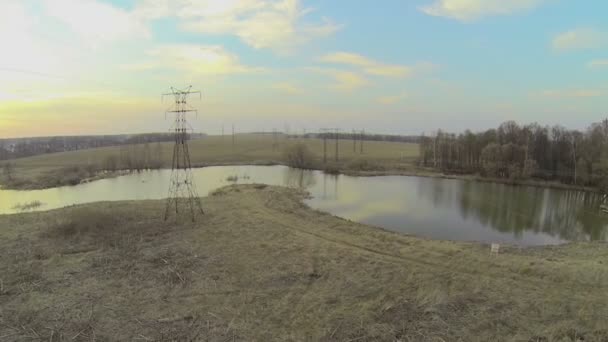 Electricity line on shore of river — Stock Video