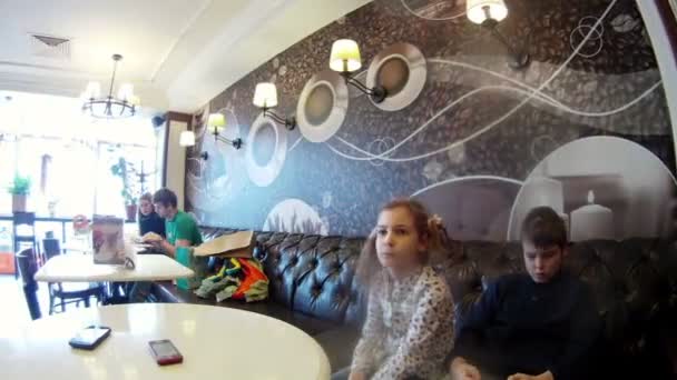 Family sitting at table in cafe — Stock Video