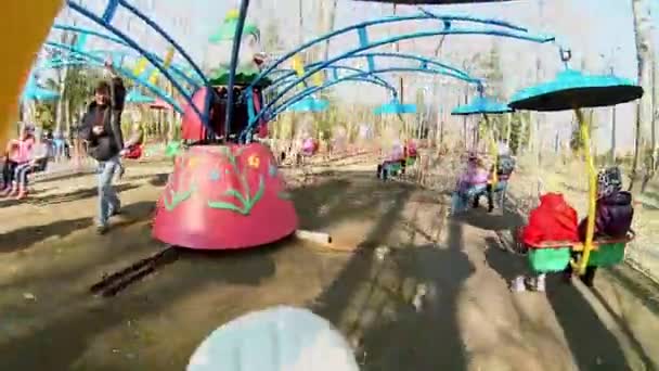 Man draait carrousel met kinderen — Stockvideo