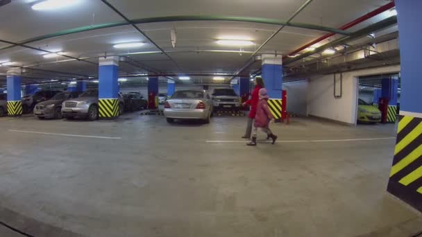 As pessoas caminham no estacionamento interior — Vídeo de Stock