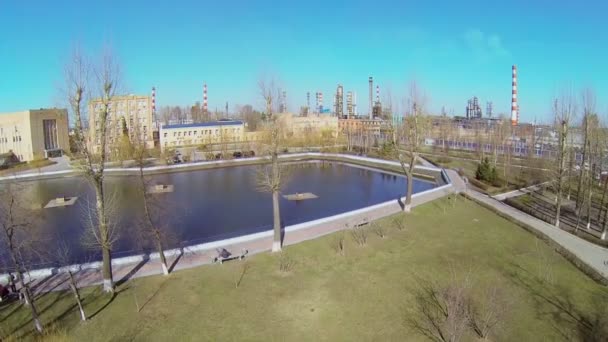 Small park with pond near oil refinery — Stock Video