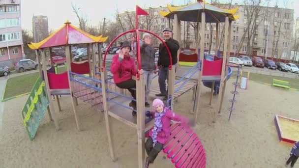 Família acenando as mãos no playground — Vídeo de Stock