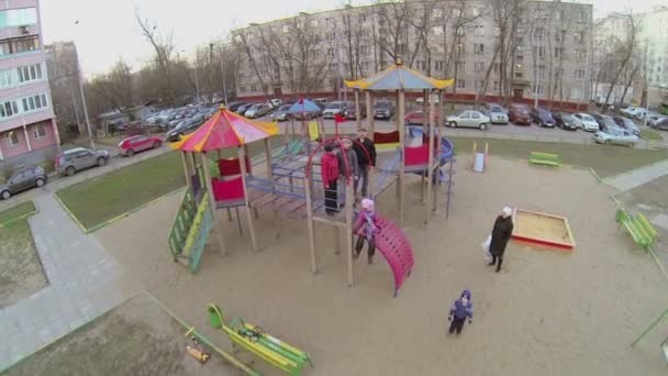 La famille se tient à l'aire de jeux pour enfants — Video