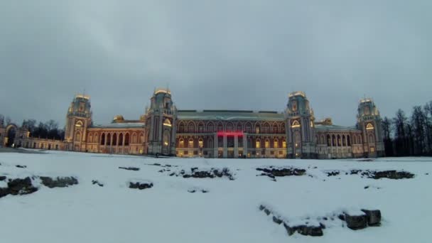 La gente camina cerca del palacio iluminado en Tsaritsyno — Vídeos de Stock