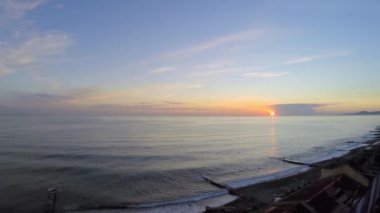 İnsanlar gün batımı sırasında deniz sahilde