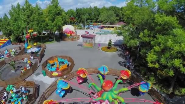 Les gens marchent par parc d'attractions avec fontaine — Video