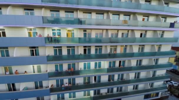 Люди стоят на балконах отеля — стоковое видео