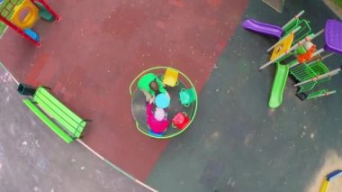 Çocuklar oyun alanında atlıkarıncada daireler çiziyor