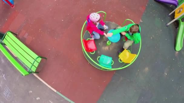 Barn cirkling på karusellen på Playground — Stockvideo