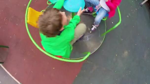 Crianças circulando no carrossel no parque infantil — Vídeo de Stock