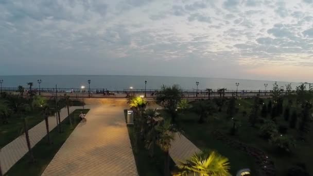 Mensen lopen door kade aan zee kust — Stockvideo