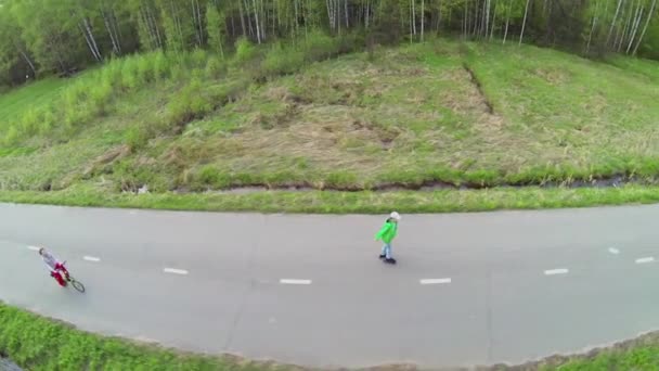 Woman rides on bike with children — 图库视频影像