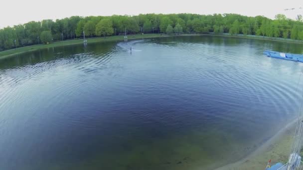 Surfer rides by pond — Wideo stockowe