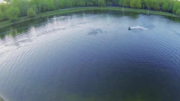 Surfer rides by pond — Stock Video