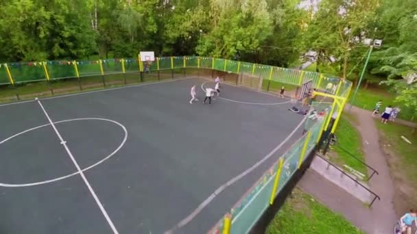 Kinderen spelen bal op omheinde Speeltuin — Stockvideo