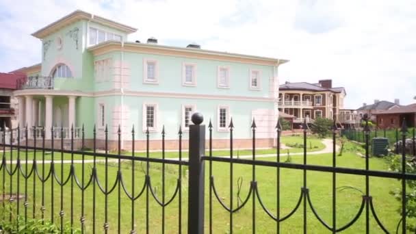 Beautiful two storey cottage under construction with black fence — Stock Video