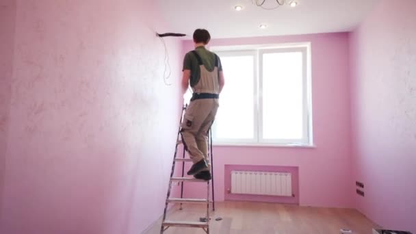 Человек в рабочей одежде поднимается по лестнице — стоковое видео