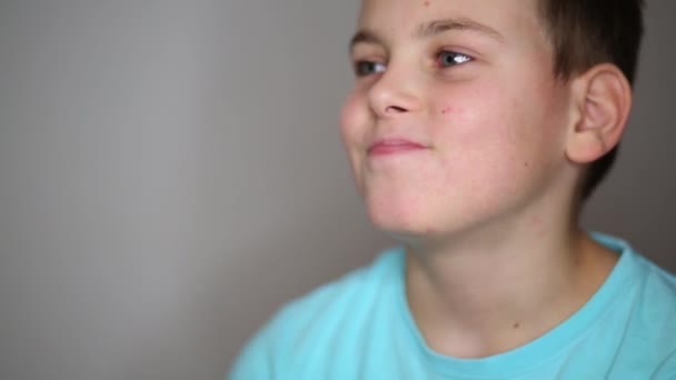 Portrait of handsome teen boy in T-shirt restrains smile — Stock Video