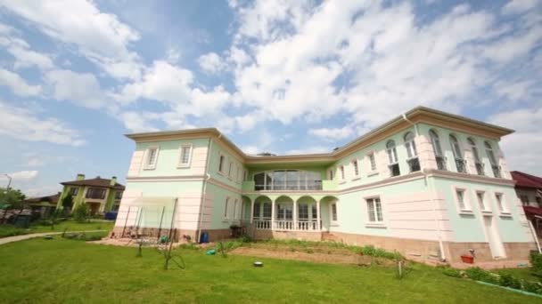 Belle maison de deux étages en construction et arbre sur vent le jour d'été 