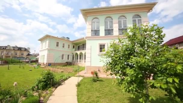 Casa de dos plantas en construcción, camas de jardín en el día de verano — Vídeo de stock