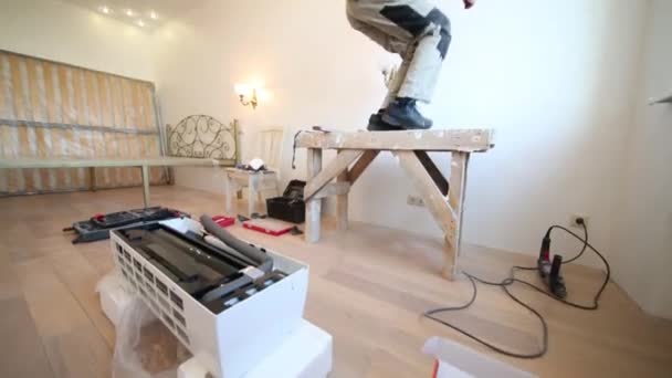 Werknemer klimt op stand in appartement — Stockvideo