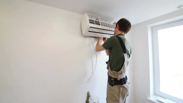 Man sets indoor air conditioner — Stock Video