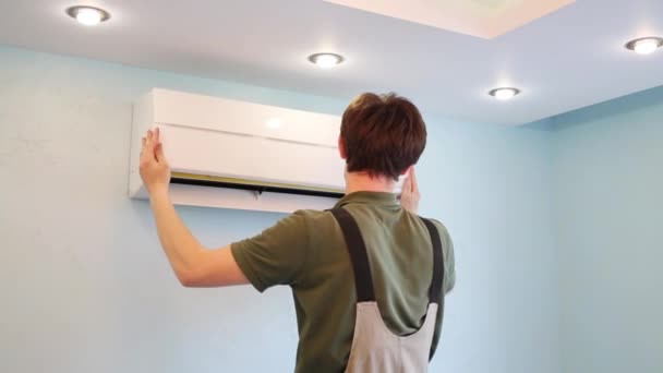 Man in overalls sluit indoor unit Air Conditioner — Stockvideo