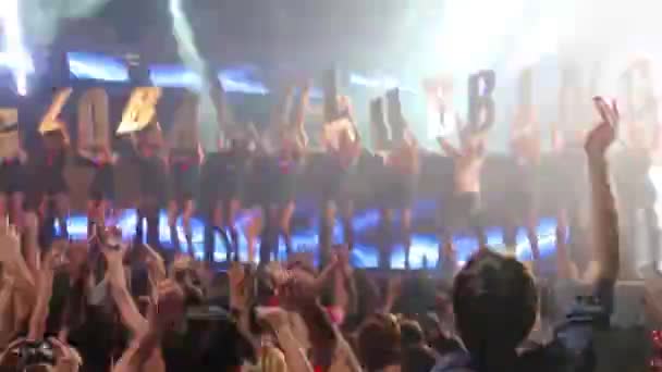 Showgirls hold letters GLOBALCLUBBING and crowd dance — Stock Video