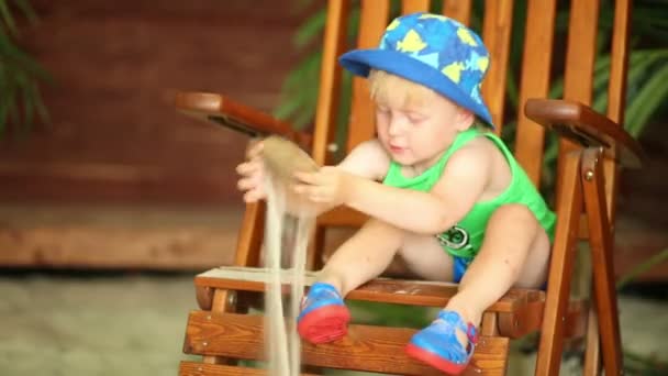 Chlapec sedí na křesle — Stock video