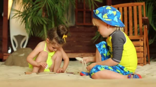 Mädchen und Junge spielen mit Sand — Stockvideo