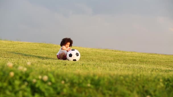 Pequena menina bonito corre com balão de futebol inflável prado verde — Vídeo de Stock