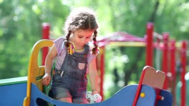 Örgüler ile küçük kız bir sabun köpüğü oynuyor.