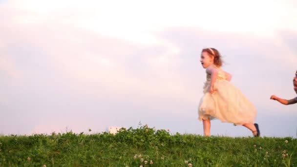 Two girls in dresses play catch-up — Stock Video