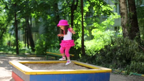 Meisje lopen over de zandbak. — Stockvideo