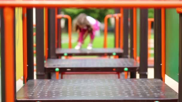 Chica escalando en el patio de recreo . — Vídeos de Stock