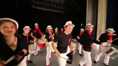 On üç kişilik müzik grubu provada sahnede davul çalıyor