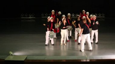 Lider davul çalma ile şapkaonlu on dört kişilik müzik grubu